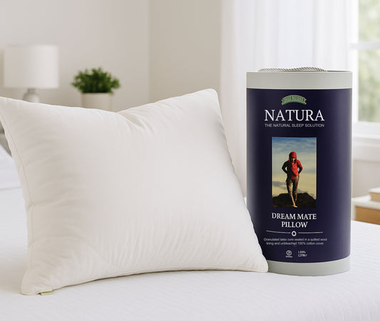 Natura Dream Mate Pillow packaging on a bed with a pillow