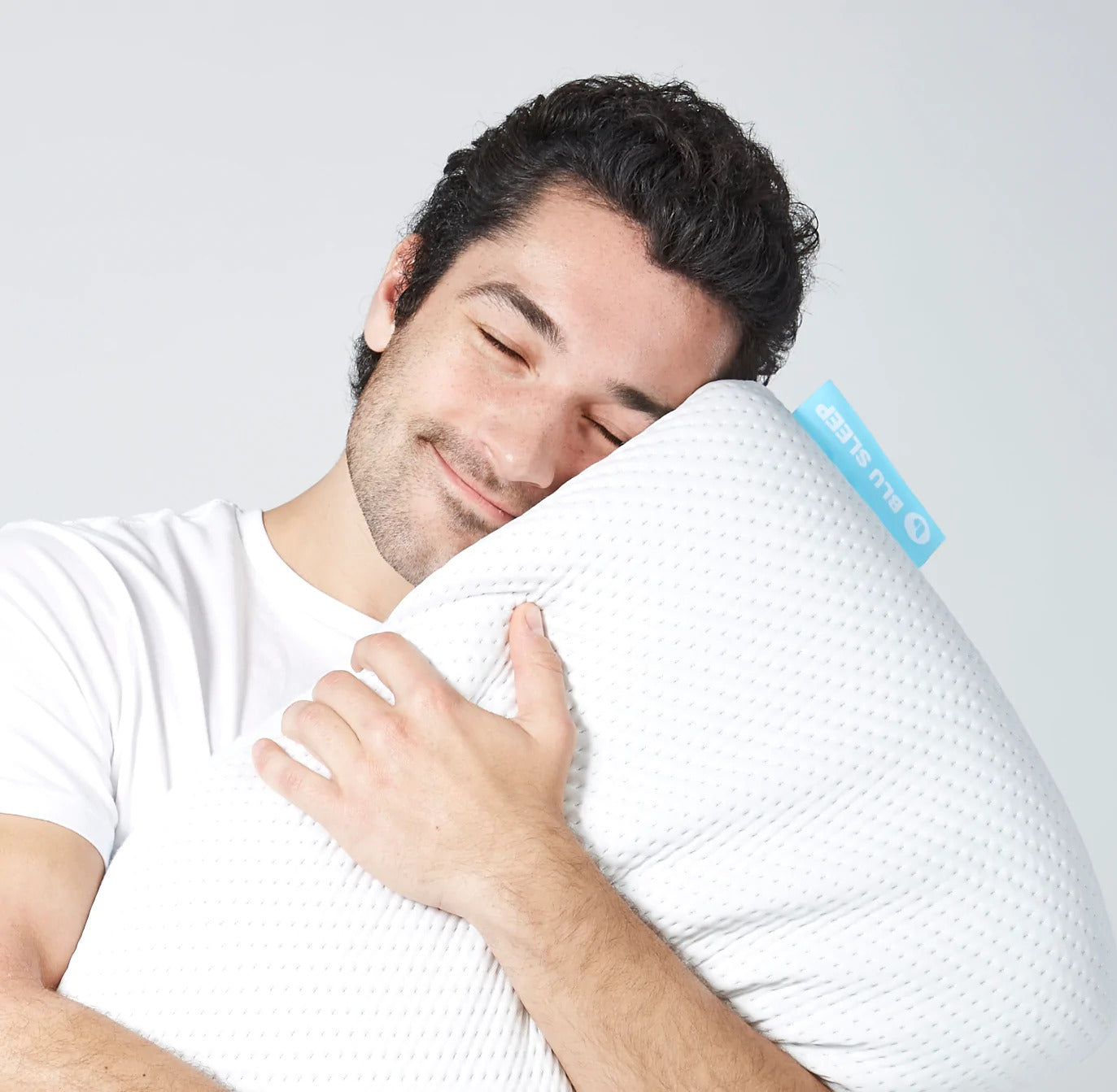 Man hugging a Blu Sleep Bio Aloe Pillow
