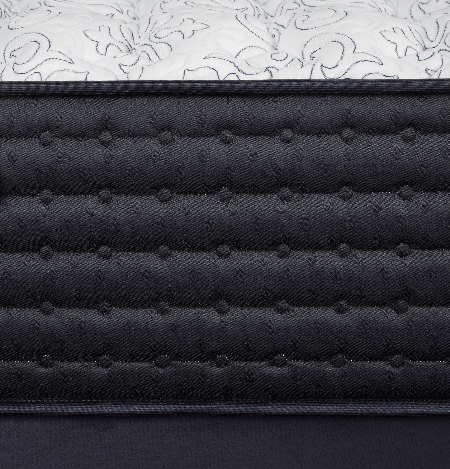 Close-up of a black quilted mattress with white floral patterned cover
