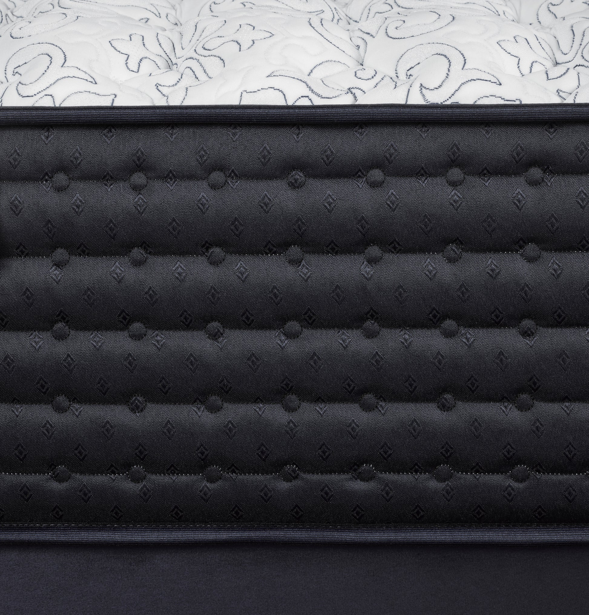 Close-up of a black quilted mattress with white floral patterned cover