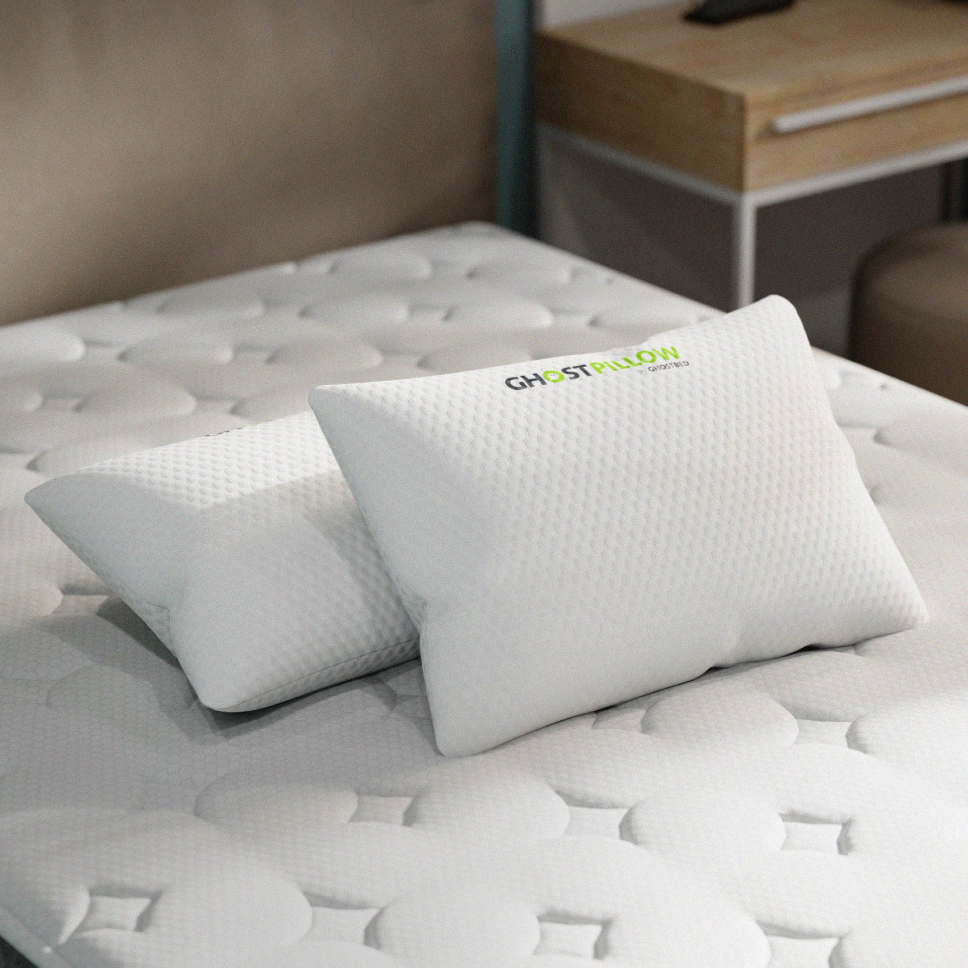 Ghost pillow on a bed with a visible brand logo