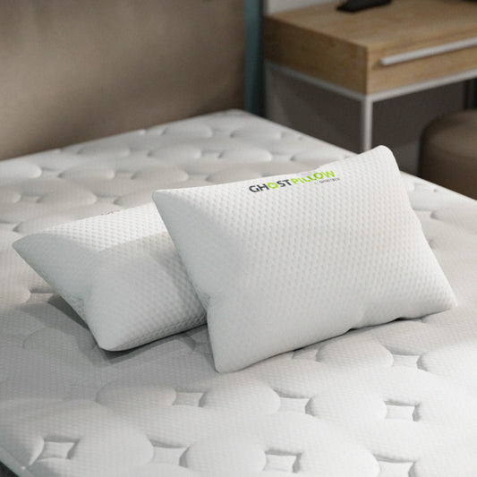 Ghost pillow on a bed with a visible brand logo