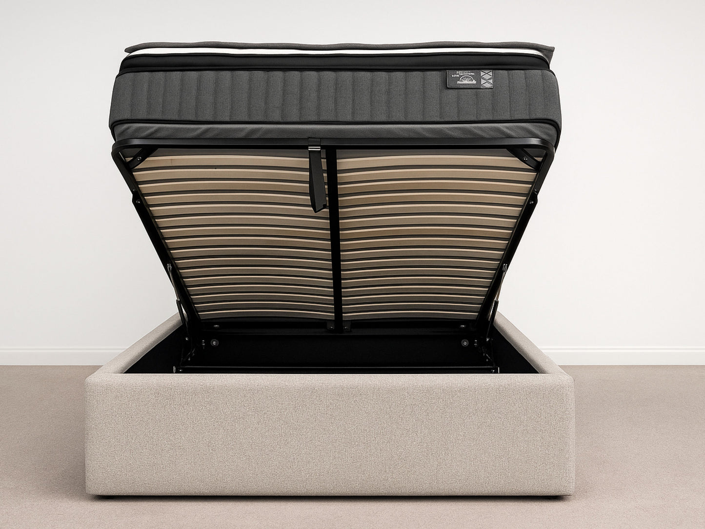 Gray upholstered bed with a black mattress on a white background